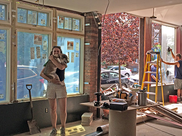 woman holding dog in store under construction